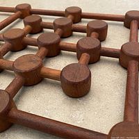 Close-up of the teak wood surface and cylindrical knob details.
