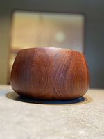 Front angle close-up of rounded teak bowl, showing wood grain and smooth finish.