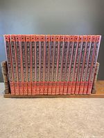 Front view of all 20 volumes and the supplement of The Encyclopedia of Photography arranged on a wooden book stand.