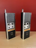 Two Fanon Outrider CB Transceiver DCB-11 vintage handheld radios with antenna, front view showing knobs and speaker grill.