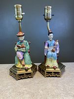 Two porcelain Chinese boudoir lamps with man and woman figures on metal bases.