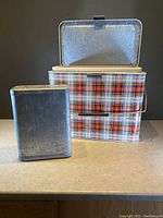Front view of the vintage tartan cooler chest with the top lid open revealing the removable metal insert box inside.
