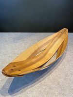 Teak bentwood bowl centerpiece shown from an angle highlighting the curved wood strips and smooth finish.