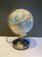 Touch Lamp World Globe on goldtone metal base and arm, showing vintage style blue and beige map detail.