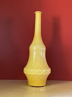 Front and side views of yellow cased glass genie bottle decanter showing shape and bubbled texture pattern on lower body.