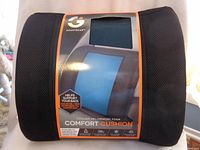 Front view of the memory foam comfort cushion packaged, showing the black mesh sides and center blue gel area with product label