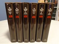 Seven hardcover books from The Palliser Novels series by Anthony Trollope with black dust jackets lined up vertically showing titles on spine.