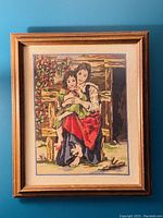 Frontal image of vintage needlepoint tapestry showing mother and daughter artwork in wood frame with scratches visible