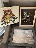 Fabric tapestry owl, framed owl print, and framed landscape painting shown together on couch