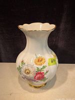 Side photo of the vase showing floral bouquet including pink rose, yellow, white, and red flowers with scalloped gold rim.