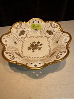 Top view of the gold trimmed porcelain bowl showing scalloped edge, gold floral design and lattice cut-outs.