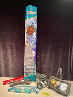 Full view of the lot items including the packaged kite, helmet light, iron weight, swimming goggles, and Harry Potter collectible.