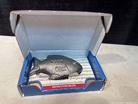 Lucky cast iron fish figurine inside open box, showing instruction leaflet
