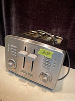 Front and angled view of Cuisinart stainless steel 4-slice toaster showing control levers, function buttons, and browning dials.