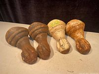 Four antique cast iron bathtub legs showing ball and claw design, top side view with paint and rust variations.