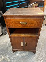 Full view of solid oak Art Deco end table showing drawer, open shelf, and closed double door cabinet below. Shows overall construction, wood finish, and condition.