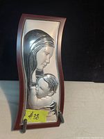 Front view of sterling silver wall art featuring a mother and child in a wooden frame.