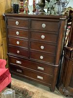 Front view of dark wooden Nautica storage cabinet showing multiple drawers and polished chrome handles.