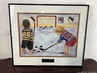 Front view of framed art print featuring young Gretzky and Lemieux playing hockey on ice with goal and pucks.