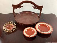 Photo of large metal tray with handle and three ashtrays on dark wooden surface
