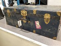 Photo of the full vintage Langmuir steamer trunk showing blue color, brass hardware with locks, and distressed surface.