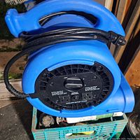 Image showing rear panel with rotary switch, built-in circuit breaker, two auxiliary 115V outlets, and power cord wrapped around handle.