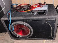 MTX Thunder subwoofer enclosure with amplifier and Pioneer stereo deck with cables on top.