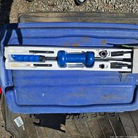9-piece Tire-Bosse dent puller set in blue with case and components laid out showing the shaft with handle and slide hammer, hooks, and other parts.