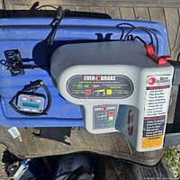 All components laid out on surface: main Even Brake unit, handheld controller and mounting hardware.