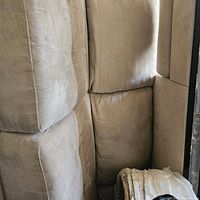 Close-up photo of beige microfiber sectional cushions showing fabric texture and condition.