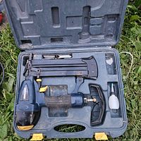 Mastercraft 2-inch Brad Nailer/Stapler case open showing the tool and accessories inside, placed on grass.