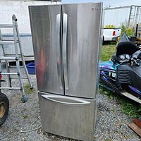 Exterior front view of stainless steel French door refrigerator showing two doors and bottom freezer drawer