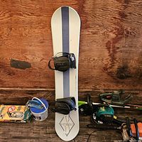 Front/top side of the snowboard showing white base with a dark gray stripe and black bindings.