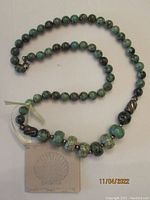 Full view of the 20-inch turquoise and sterling silver bead necklace on a white background.