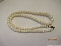 Full view of the alabaster bead necklace laid out showing length and clasp.
