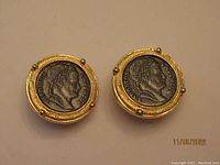 Front view of round Carolee earrings with Napoleon profile coin design set in gold-tone metal frames.