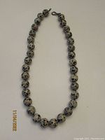 Full view of the handmade cheetah stone necklace showing round spotted beads arranged in a strand with hook clasp.