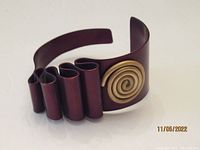 Front and side view of brown cuff bracelet showcasing ribbon design and gold spiral accent.