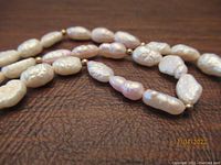 Close-up of natural fresh water pearls and small gold filled beads on the necklace.