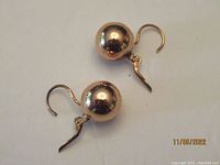Pair of rose gold tone spherical ball earrings made of sterling silver with leverback hooks, shown on white background.
