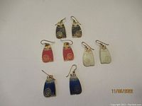 Top view of all five pairs of earrings laid out on white surface showing different colors.