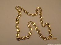 Photo showing full 26 inch gold tone mariner link necklace laid flat.