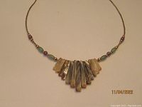 Photo showing the full length of the necklace with rectangular abalone shell pieces and round aventurine, amethyst and gold-tone beads on a thin cord.