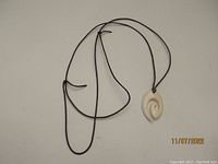 Full view of the Norwegian fisherman hook pendant on black adjustable string.