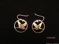 Pair of round Wild Bryde earrings with flying blue heron in circular frame on black background