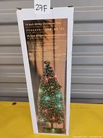 Photo of the original box showing an image of a 14 inch glitter Christmas tree with LED lights and product details.