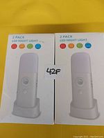 Front view of two boxes each containing 2 LED night lights showing product image and features on front of packaging.