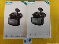Front view of two boxed M48 true wireless earbuds in charging cases on yellow background.