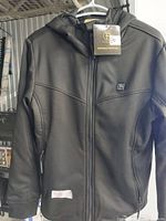 Front view of black Ptahdus heated jacket with hood, zipper front, side pockets, and logo on chest.
