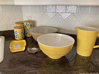 Photo of all items arranged on countertop showing canisters, mixing bowls, jug, and spoon rest